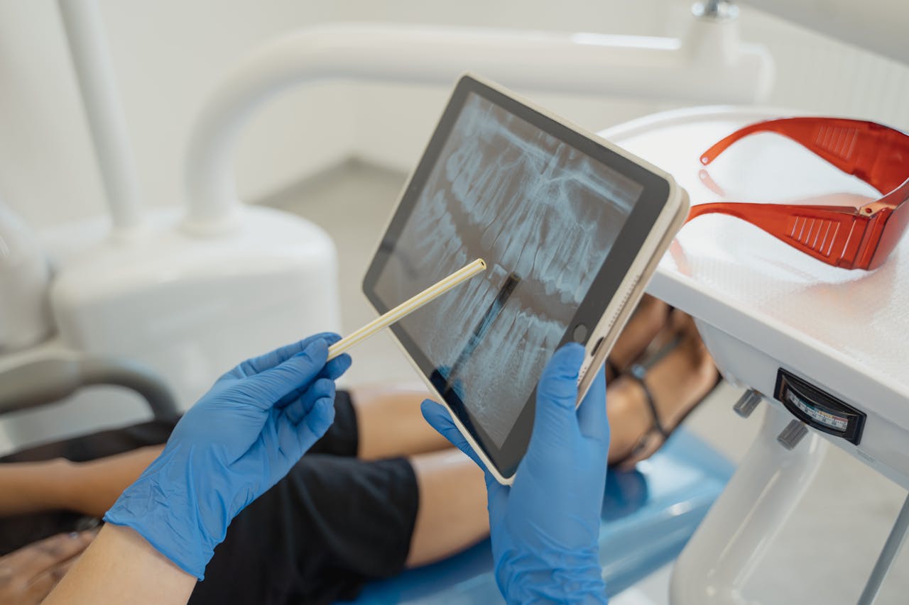 Crafting Captivating Headlines: Your awesome post title goes here Dentist showing dental x-ray on tablet to patient in a modern clinic setting.